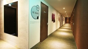A hotel corridor with a modern design, featuring a sign that reads "At noon" and a door labeled "611". - Hotel At noon (Jeju City)