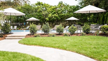 Una piscina al aire libre de temporada, sillones reclinables de piscina