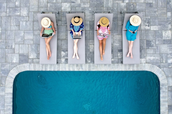 Una piscina al aire libre de temporada, sillones reclinables de piscina