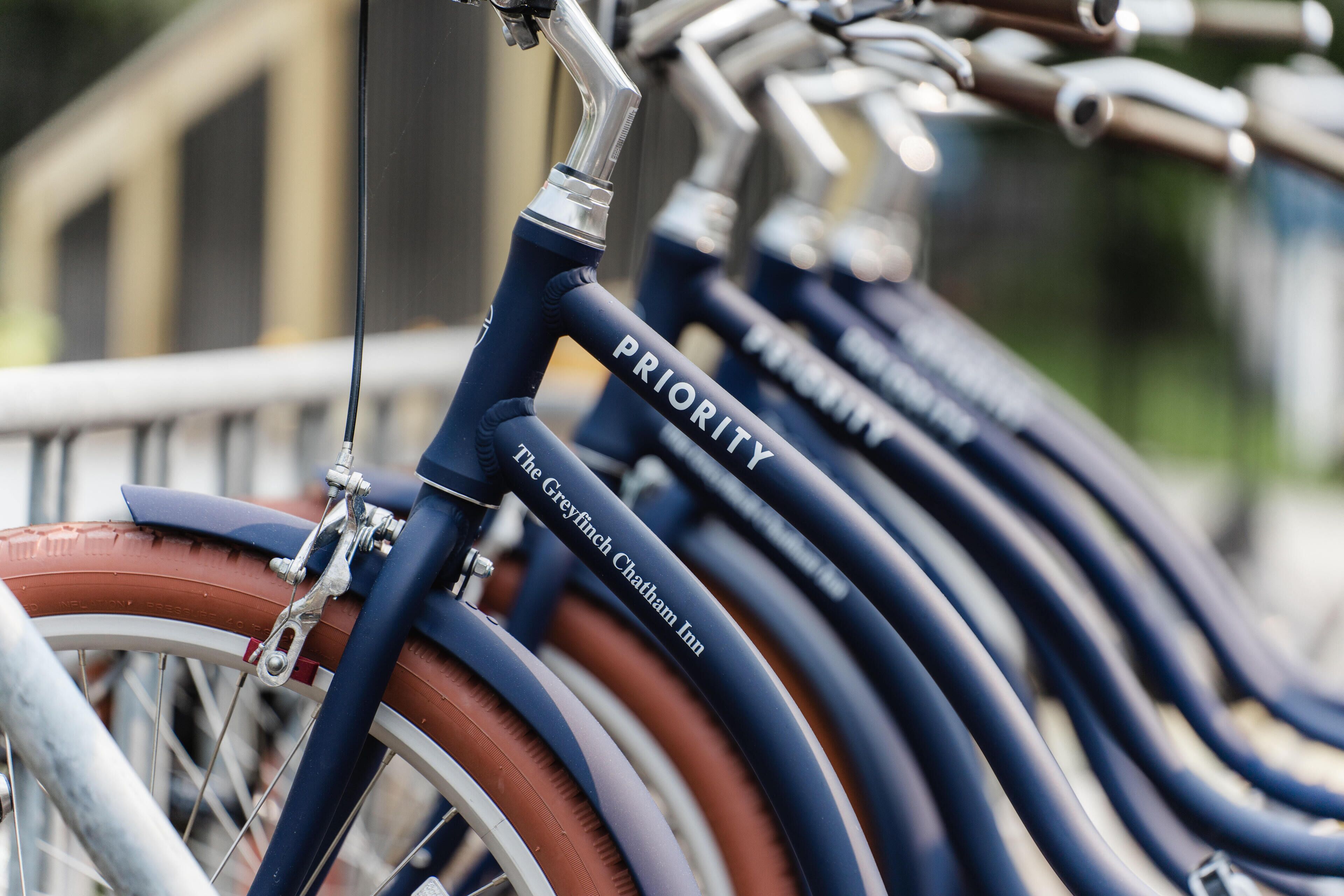 Une rangée de vélos dont le cadre porte l’inscription « PRIORITÉ », ce qui indique qu’il s’agit d’un programme de vélos en libre-service.