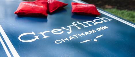 Et bord med teksten "Greyfinch Chatham Inn" og to røde puder.