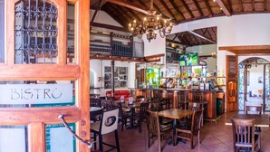 A restaurant interior with wooden furniture, a bar area, and a sign reading "BISTRO". - Estrada Hotel & Bistro (Granada)