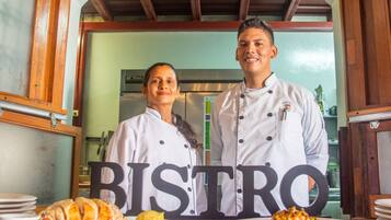 Um bistrô com interior em madeira, um letreiro grande com a palavra 'BISTRO' e pratos de comida no balcão.