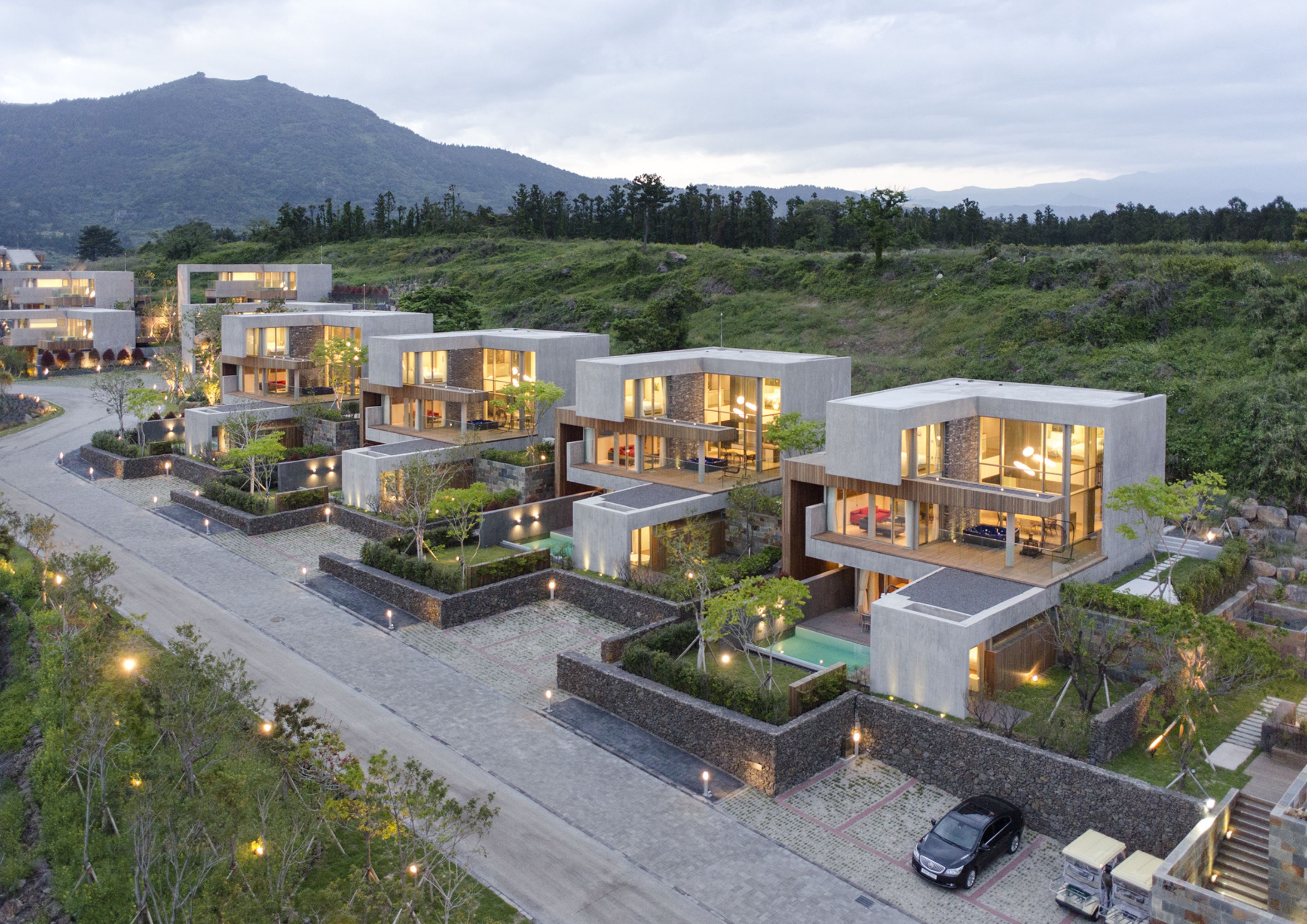 Un complexe résidentiel moderne composé de plusieurs immeubles à deux étages, chacun doté de grandes fenêtres et de terrasses extérieures.