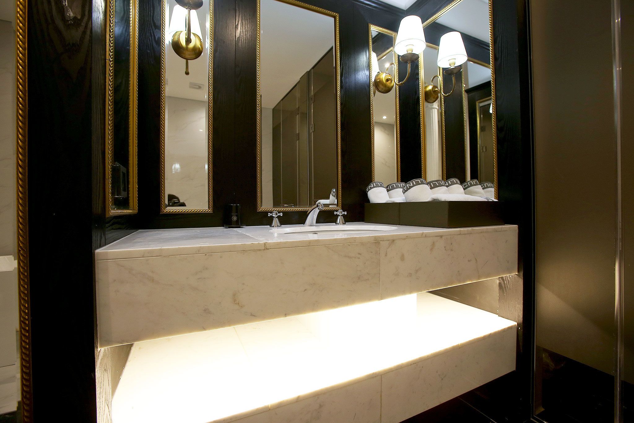 Un baño con un espejo grande, un lavamanos y un mueble de tocador.