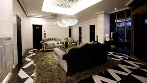 A modern lobby with a sofa, a chandelier, and a check-in counter. - Hotel Cullinan Yongin (Yongin)