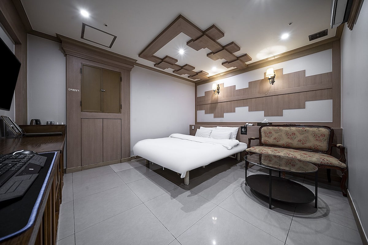 Une chambre à coucher moderne avec un lit, un bureau et une chaise.