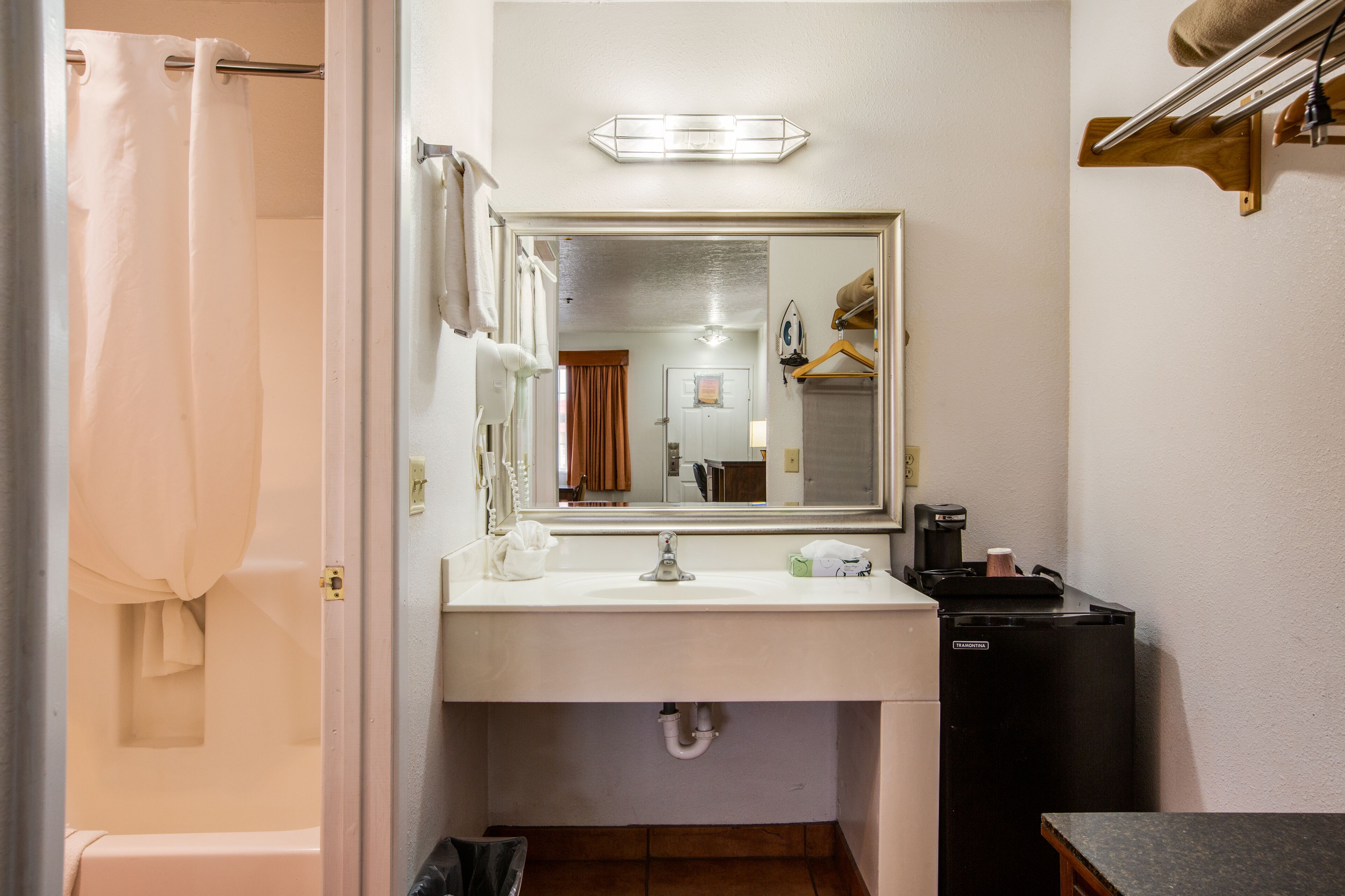 A bathroom with a sink, mirror, and shower curtain.