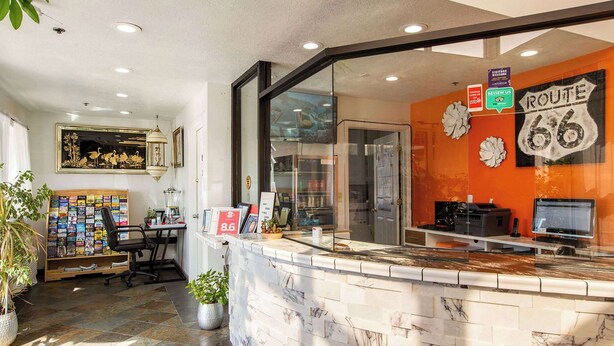 A reception desk with a marble design, a Route 66 sign, and a framed picture on the wall. - Sandia Peak Inn Old Town ABQ, a Howard Johnson by Wyndham (Albuquerque)