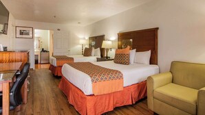 A hotel room with two beds, a desk, a chair, and a sofa. - Sandia Peak Inn Old Town ABQ, a Howard Johnson by Wyndham (Albuquerque)