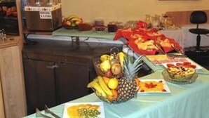 Mesa de buffet com diversas frutas e pratos.