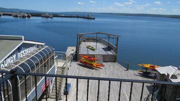 A dock with kayaks and a boat named "Lundy Resthouse" on a calm body of water.