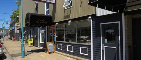 A waterfront building with a sign for 'Fundy Restaurant' and 'Dockside Suites'.