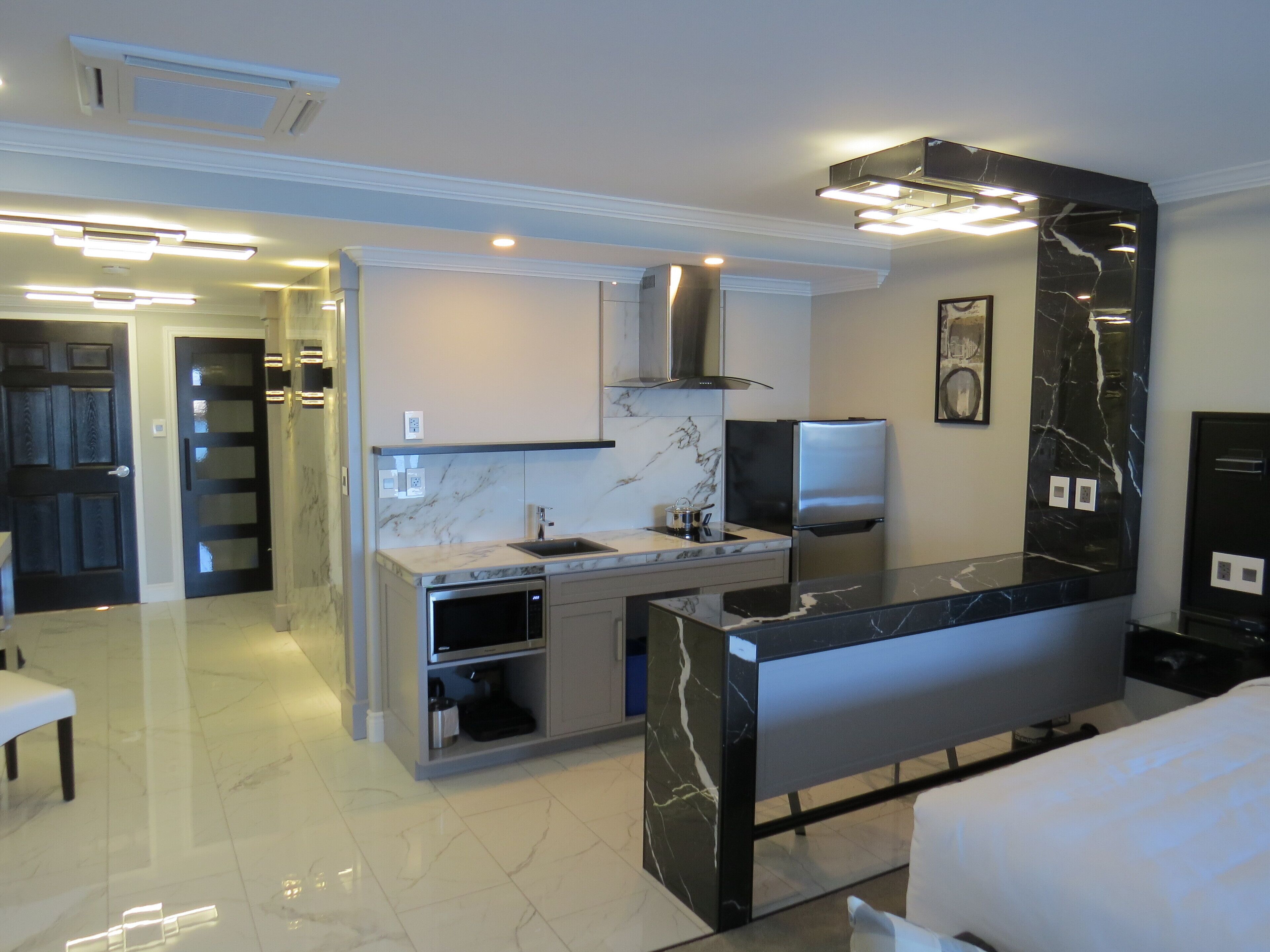 A modern kitchen with a marble countertop, stainless steel appliances, and a built-in oven.