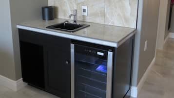 Uma cozinha compacta com lava-louças embutida, pia e painel de fundo em mármore.
