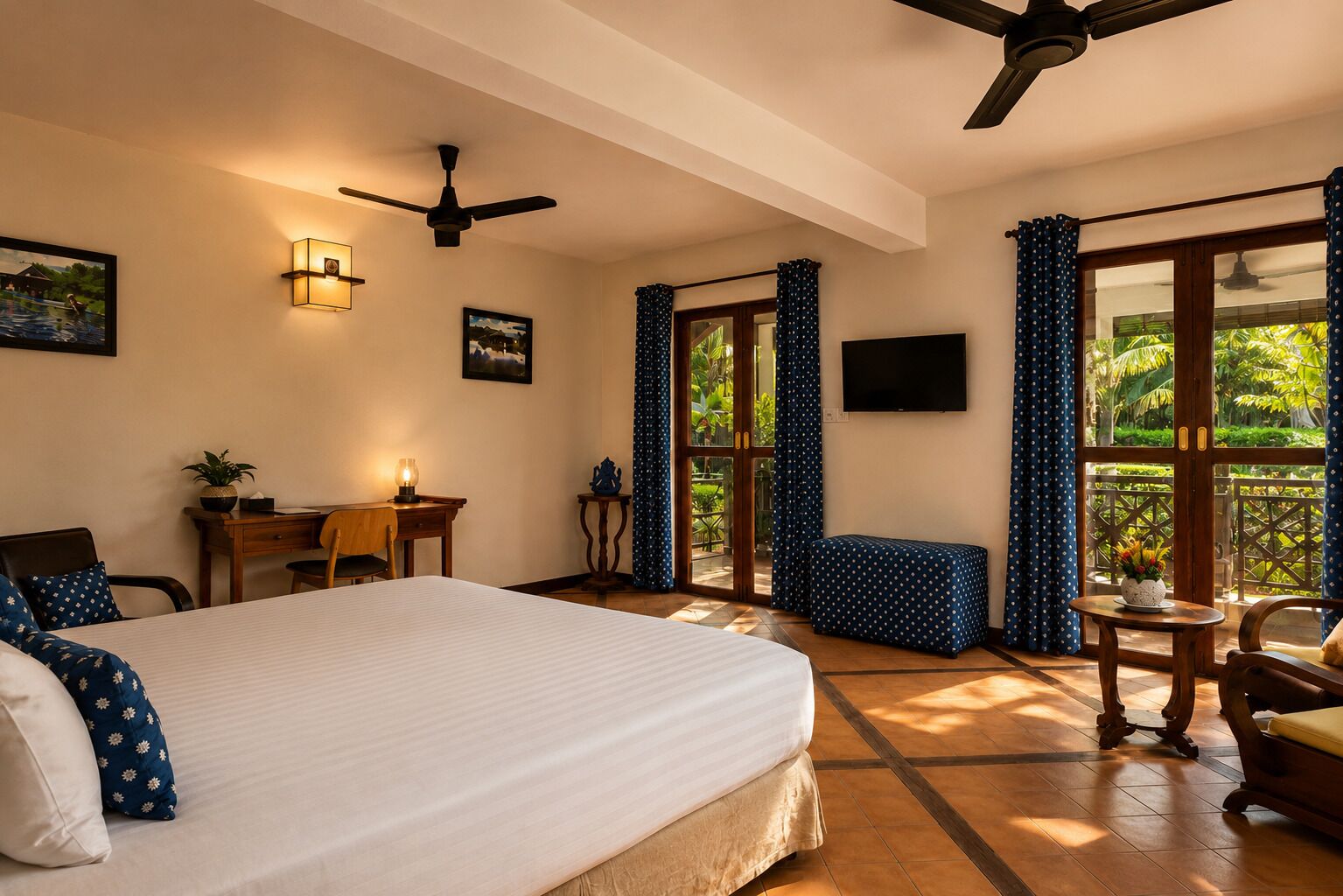 Habitación de hotel con cama, escritorio, silla y vista a zonas verdes por la ventana.