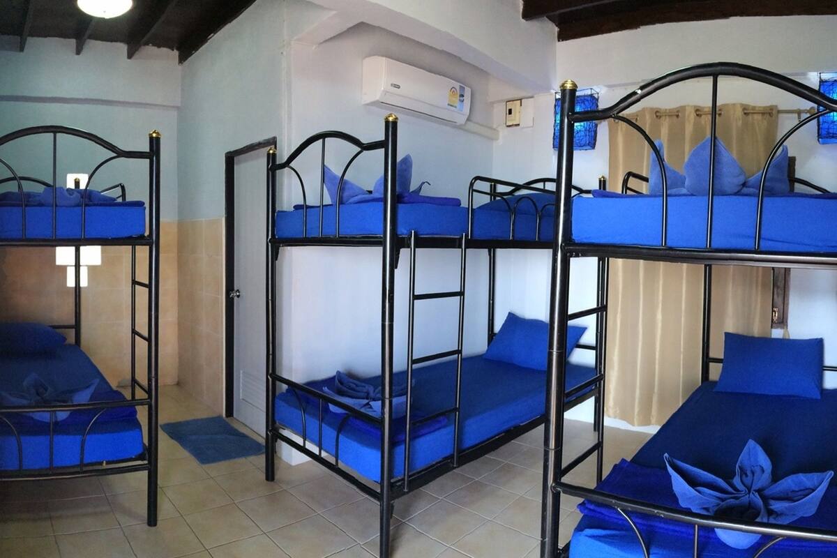 Ein Zimmer mit Etagenbetten, Deckenventilator und Klimaanlage.