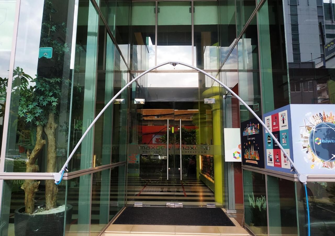 A hotel entrance with glass doors, a ramp, and a sign for 'maxon maxline hotels'.
