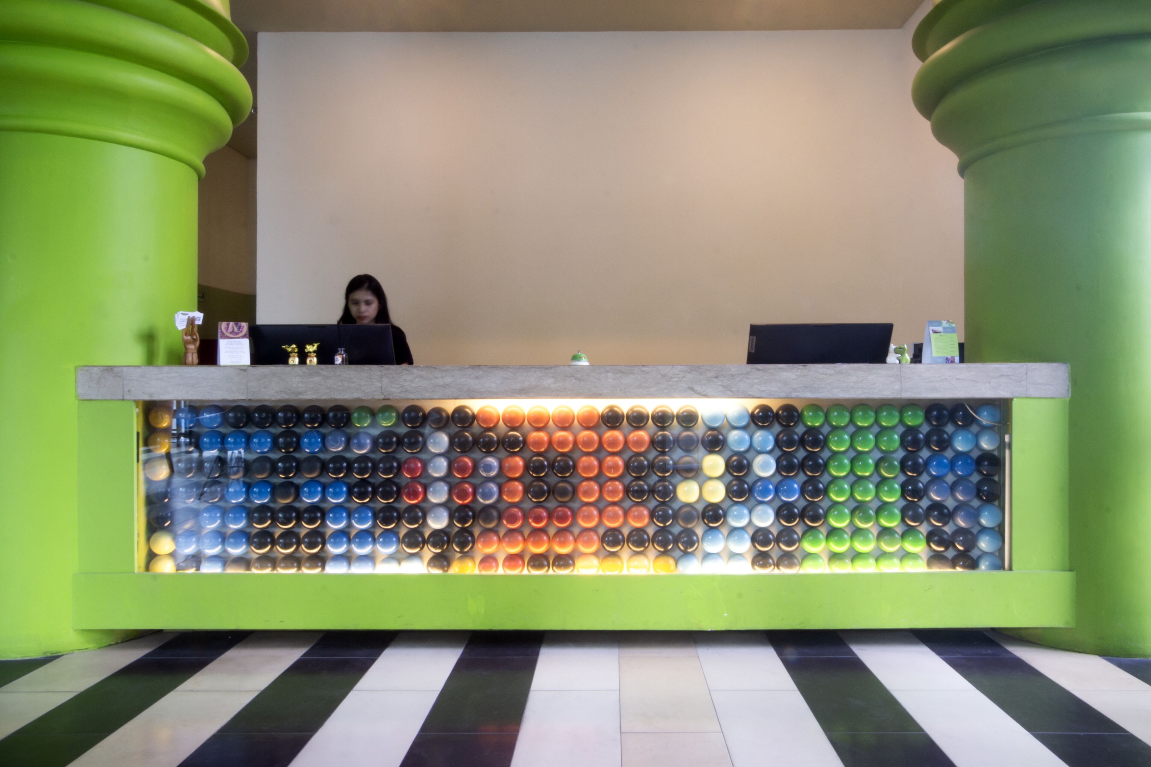 Un comptoir d'accueil orné d'une mosaïque colorée faite de bouteilles.