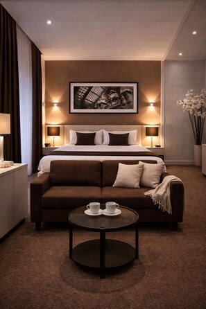 A hotel room with a bed, a sofa, a coffee table, and a framed artwork on the wall. - Stelle Hotel The Businest (Naples)