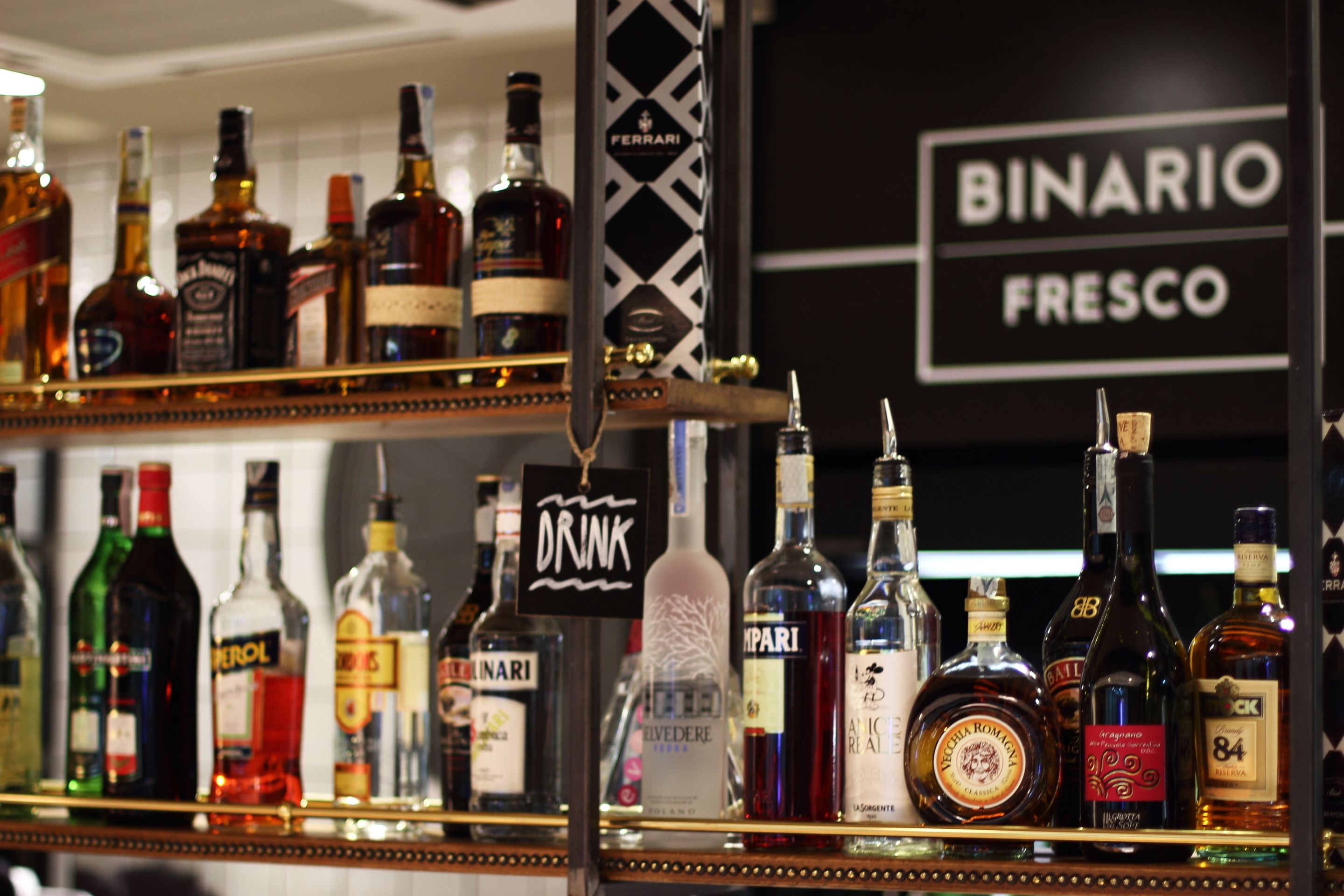 A bar with various liquor bottles and a sign that reads "DRINK".