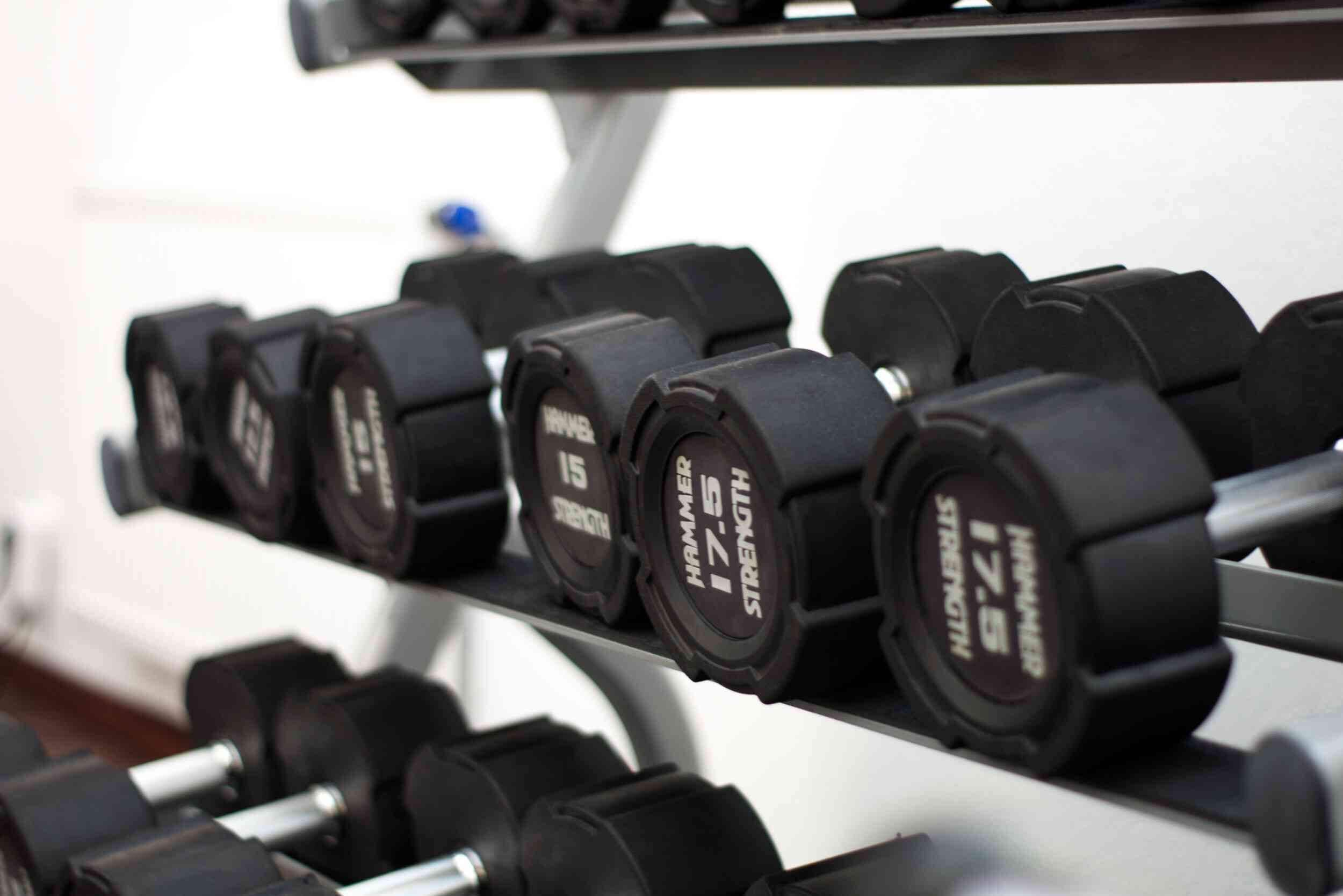 A rack of black dumbbells with weight markings.