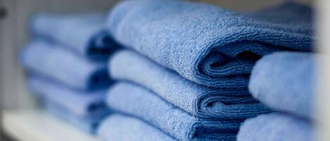 A stack of folded towels on a shelf.