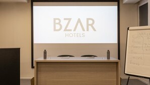 Un comptoir d’accueil doté d’un écran affichant le nom « BZR HOTELS » et d’un tableau blanc indiquant les différents emplacements des hôtels.