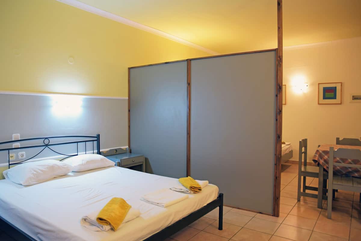 Una habitación de hotel con cama, escritorio, silla y armario.
