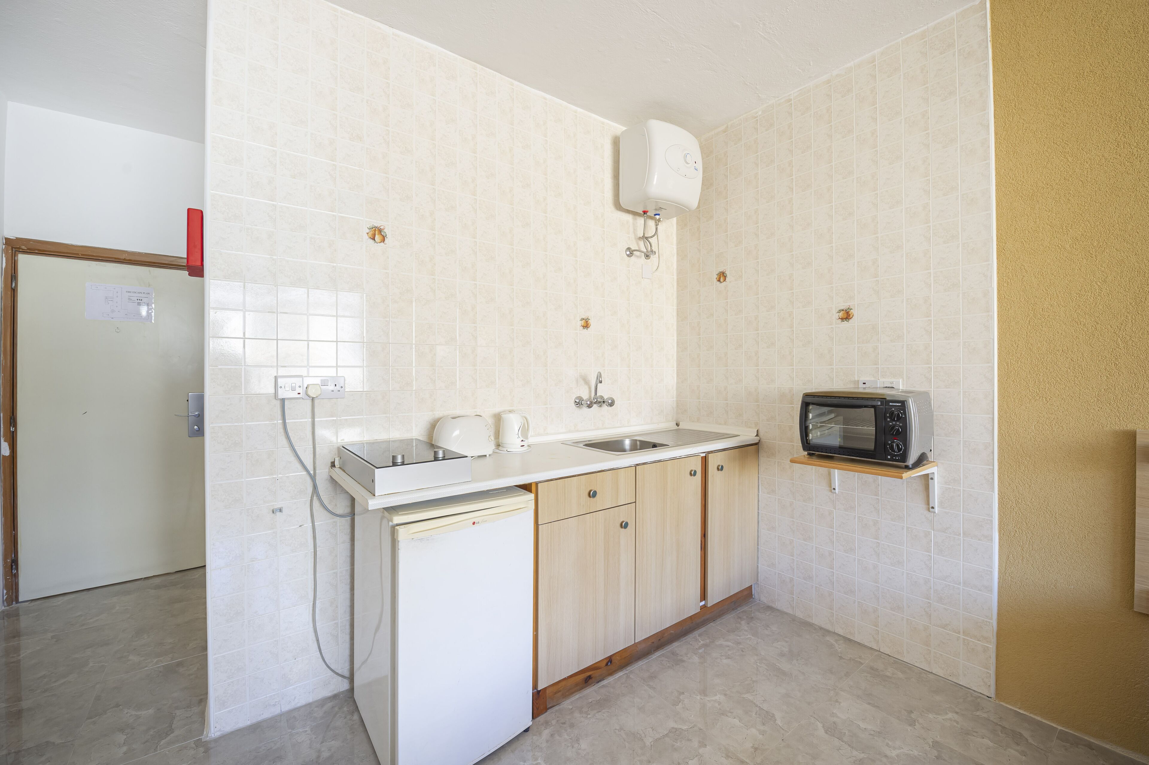 Een kleine keuken met een spoelbak, een magnetron en een vaatwasser.