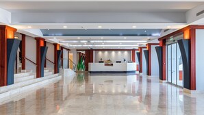 Un hall d’entrée spacieux, doté d’un comptoir de réception, d’un sol en marbre et d’une architecture moderne.