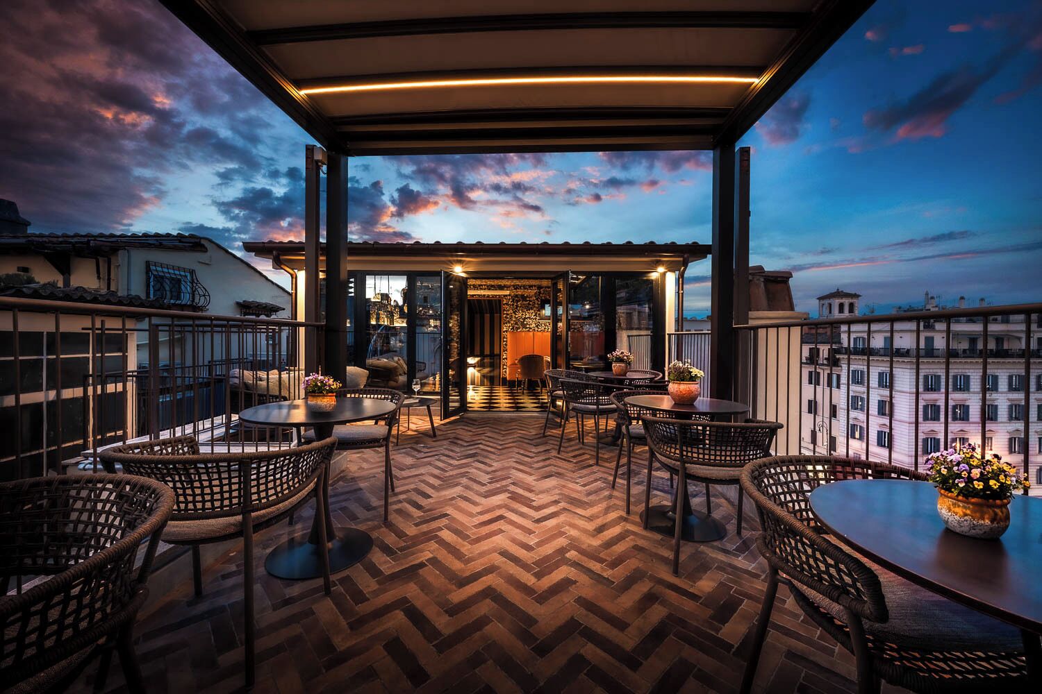 Une terrasse sur le toit avec des sièges extérieurs, un parquet en chevrons et une vue sur le paysage urbain.