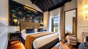 Una camera d'hotel moderna con un letto grande, un comodino, uno specchio e vista sulla città.