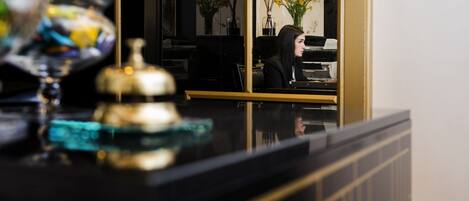A reception desk with a black counter and a glass display case containing a decorative item.