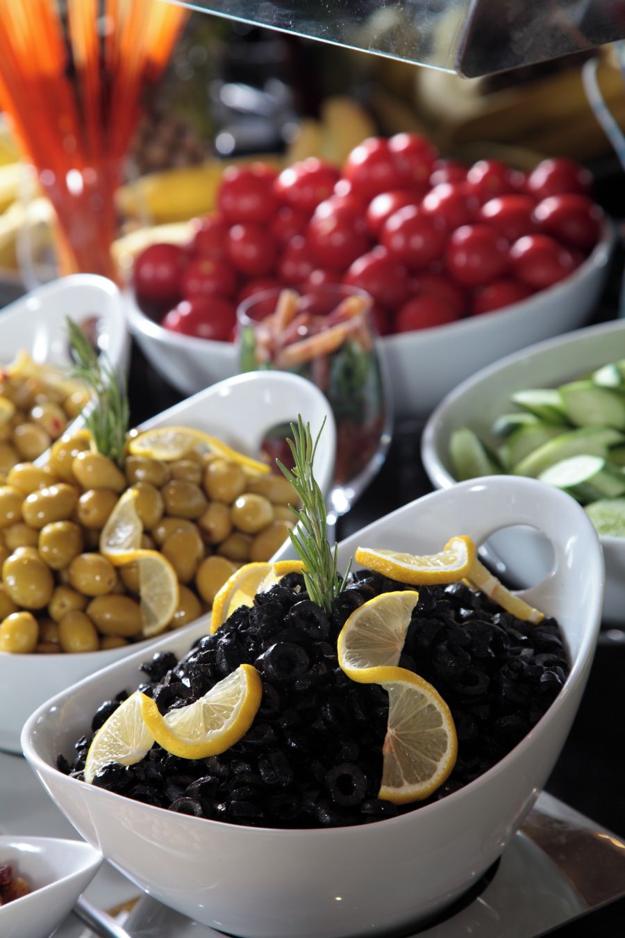 A variety of food items in bowls, including black beans, chickpeas, and cherry tomatoes.
