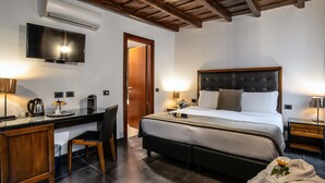 Una habitación de hotel con cama, escritorio, silla y televisor.