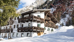 A chalet-style building with wooden balconies and a snow-covered landscape.