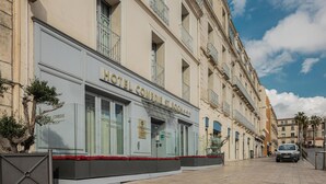 A hotel facade with large windows, a sign reading "HOTEL COMEDIE ST. ROCH", and a paved street in front. - Best Western Plus Hotel Comedie Saint-Roch (Montpellier)