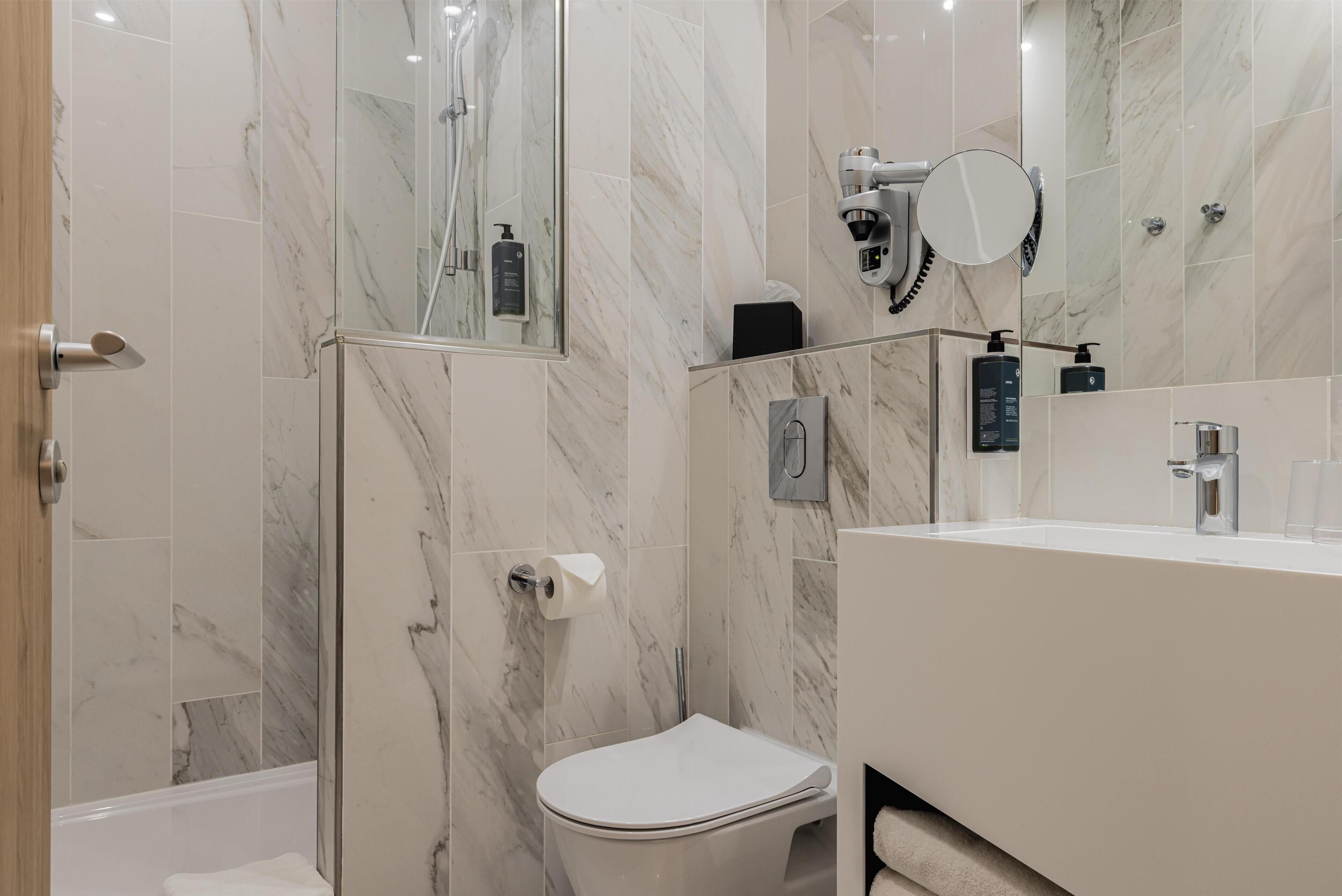 A modern bathroom with a shower, toilet, and vanity.
