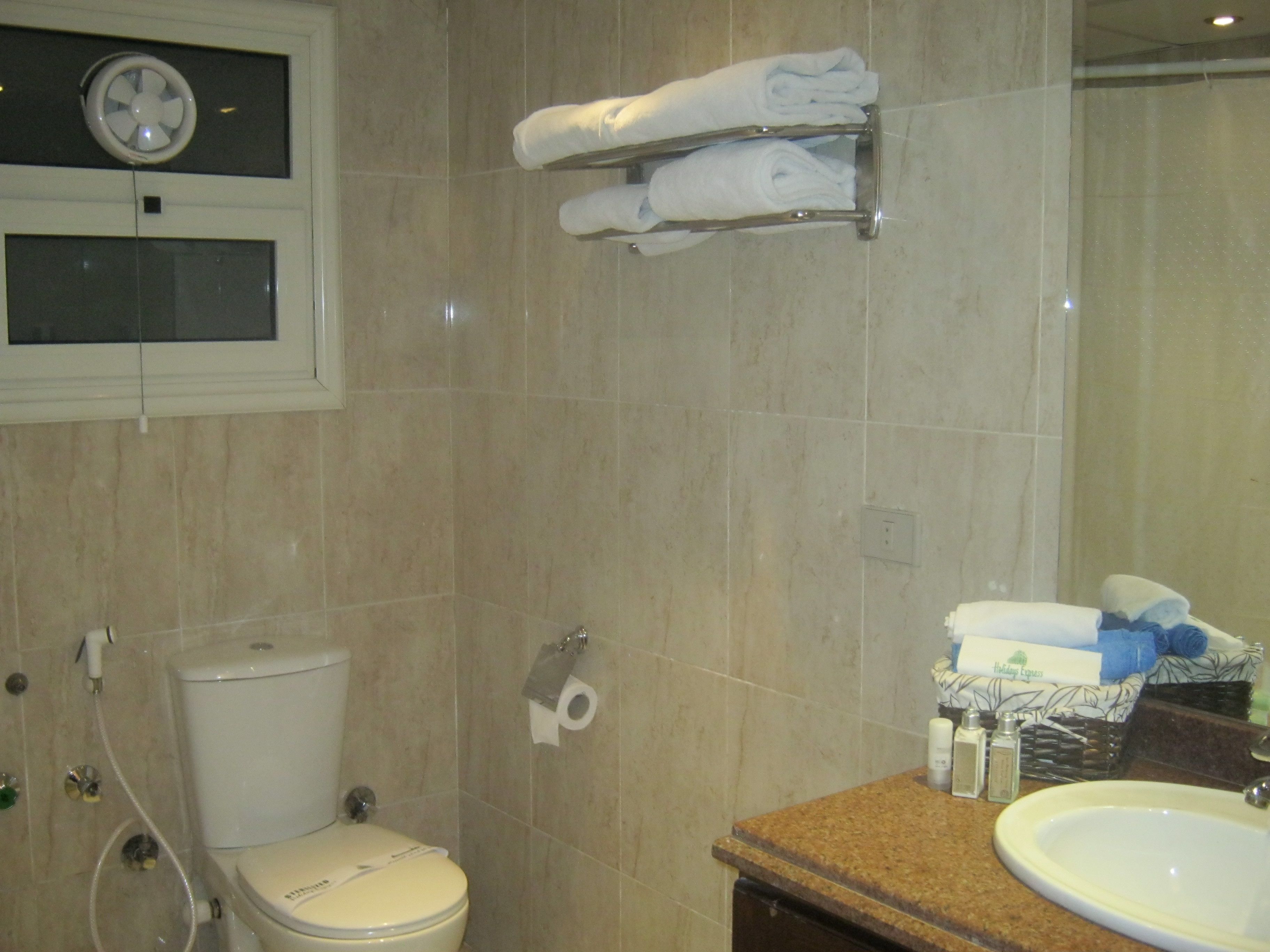 A bathroom with a toilet, a sink, and a towel rack.