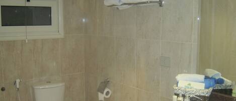 A bathroom with a toilet, a sink, and a towel rack.