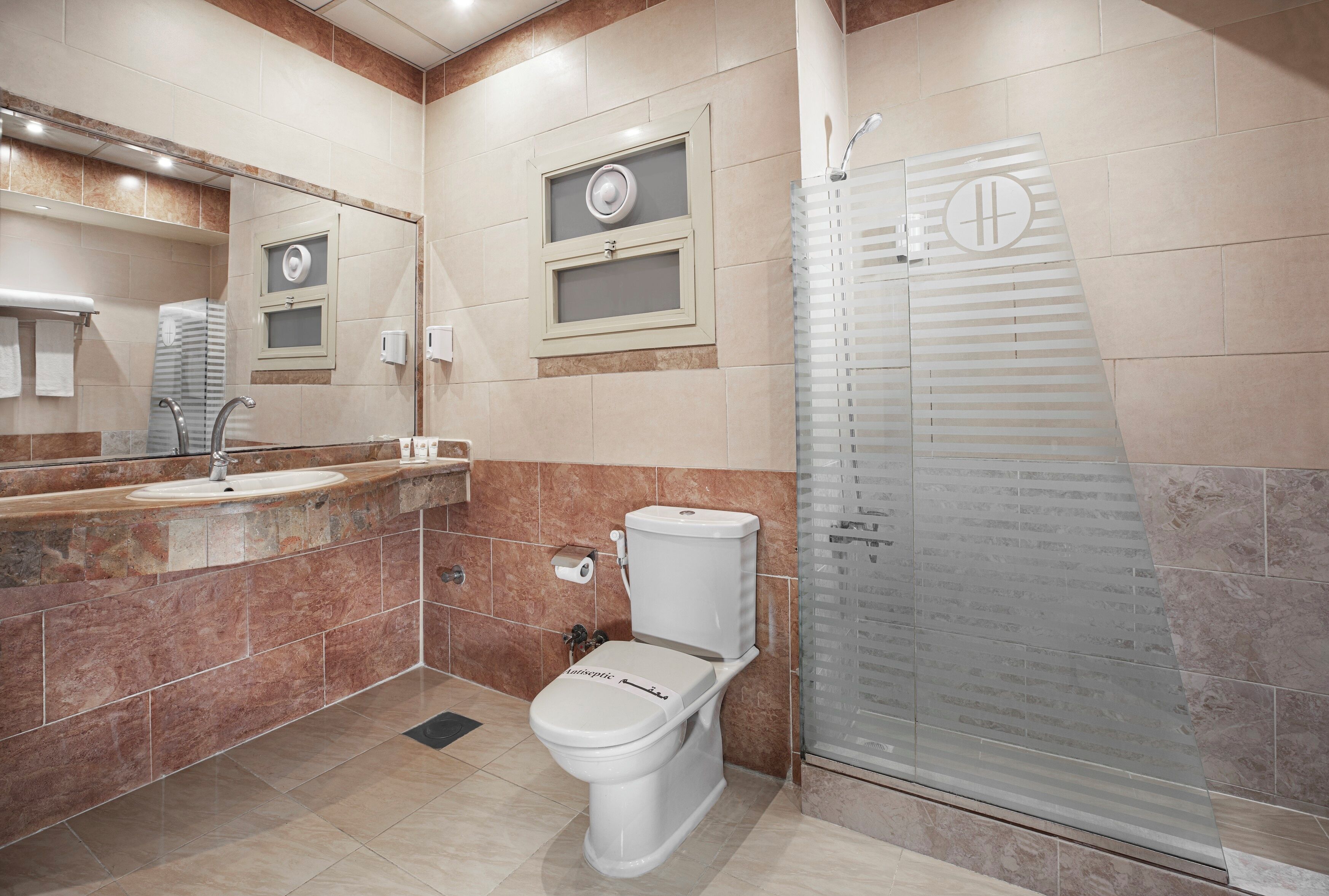 Un baño moderno con inodoro, lavabo y cabina de ducha de vidrio.