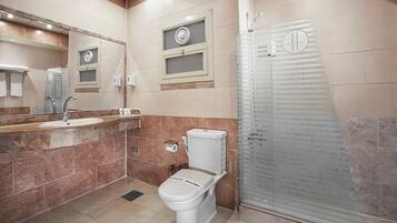 Un baño moderno con inodoro, lavabo y cabina de ducha de vidrio.