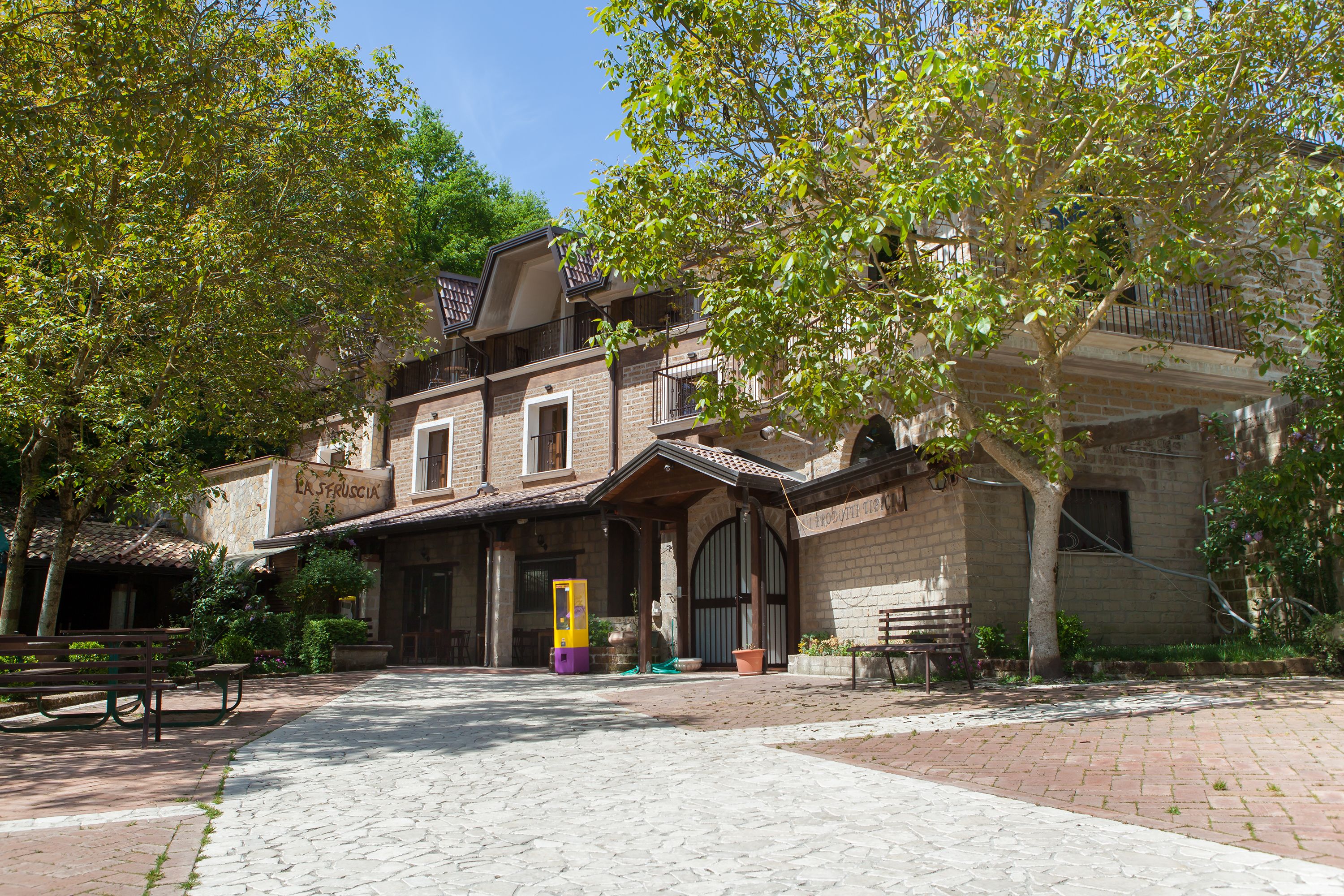 A building with a brick facade, a covered entrance, and a bench in the foreground.