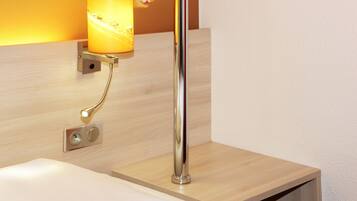 Un baño moderno con tocador de madera, grifo cromado y lámpara de pared.