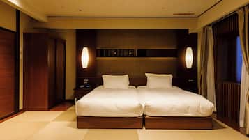 Una cama doble con estructura de madera, dos mesitas de noche y lámparas fijadas a la pared.