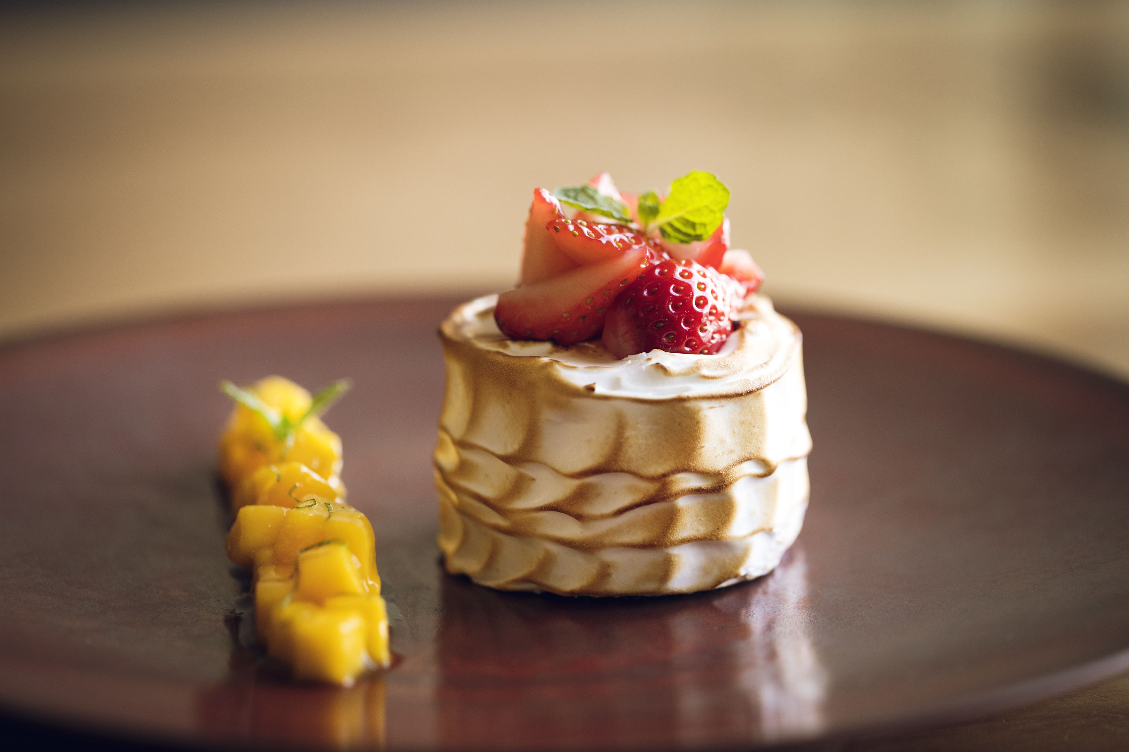 A dessert on a dark plate with a blurred background.