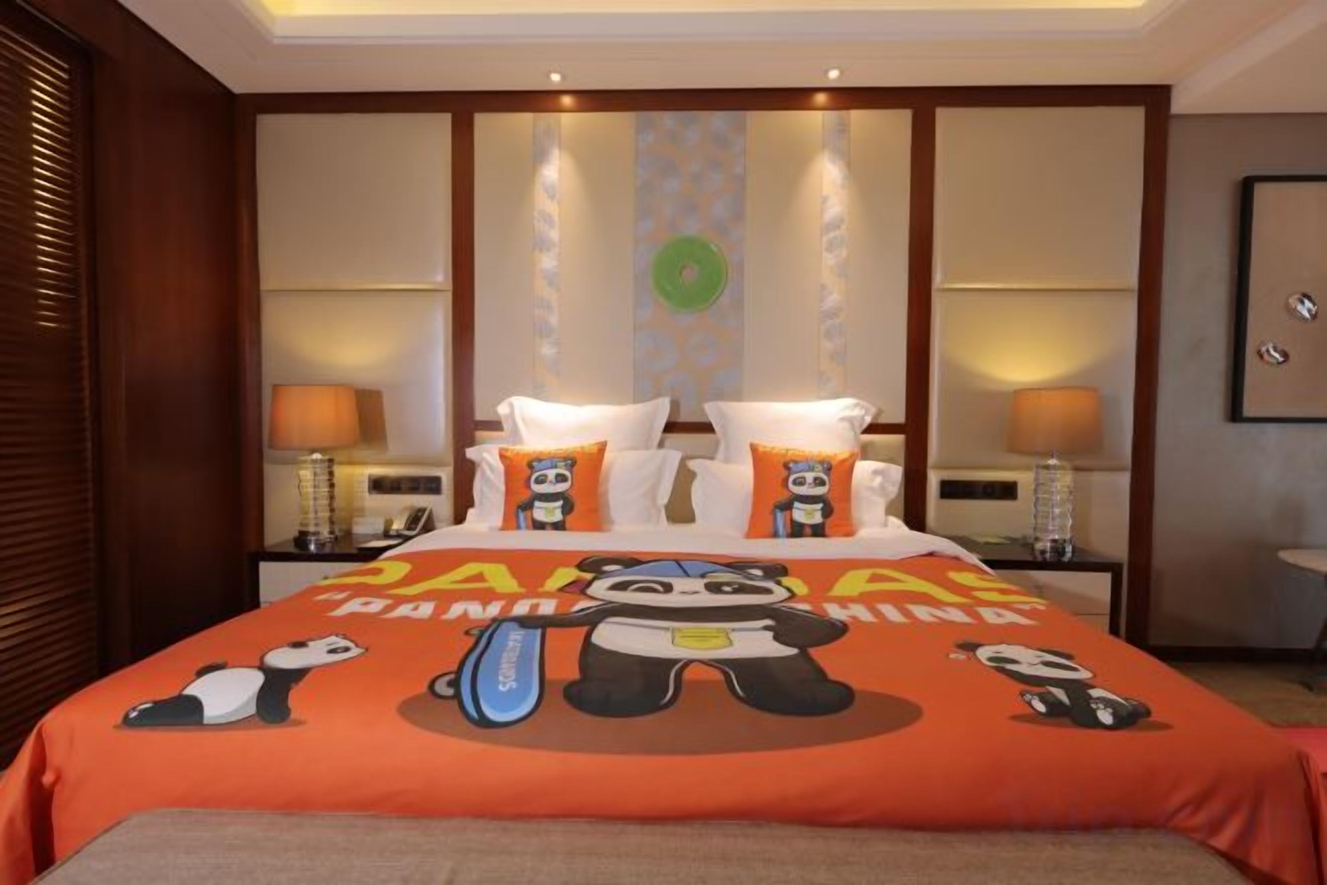 A hotel room with a large bed, two bedside tables, and a nightstand with lamps.