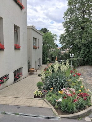 A courtyard with a white building, flower boxes, outdoor seating, and a variety of plants. - Pension Jana - Domov Mládeže (Prague)