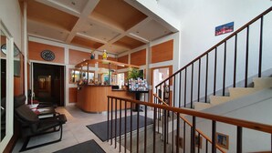 A hotel lobby with a reception desk, seating area, and a staircase. - Pension Jana - Domov Mládeže (Prague)